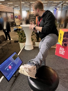 En person visar sin 3D-printade sko på en pall.