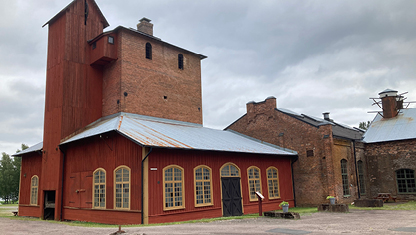 Ett gammalt järnbruk med träbyggnader och tegelbyggnader