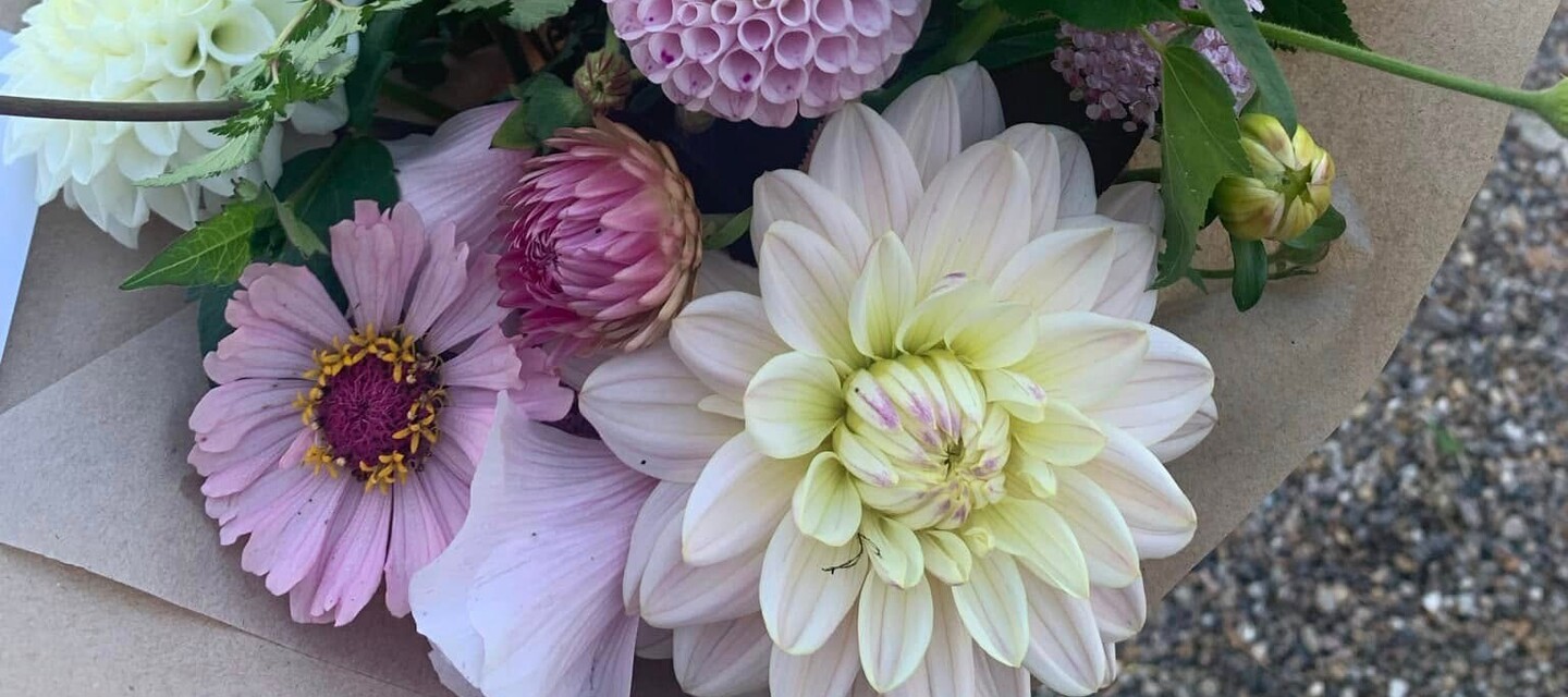 Bilden föreställer delar av en bukett med dahlior i lila toner.